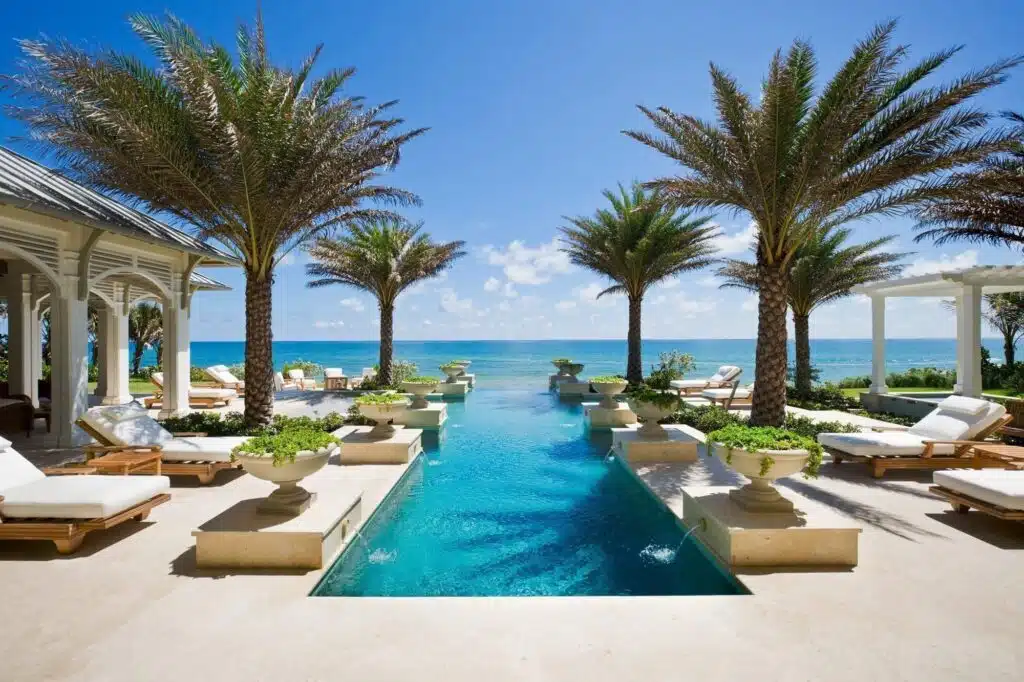 A palm-lined pool terrace running to the sea, built by Cudmore Builders