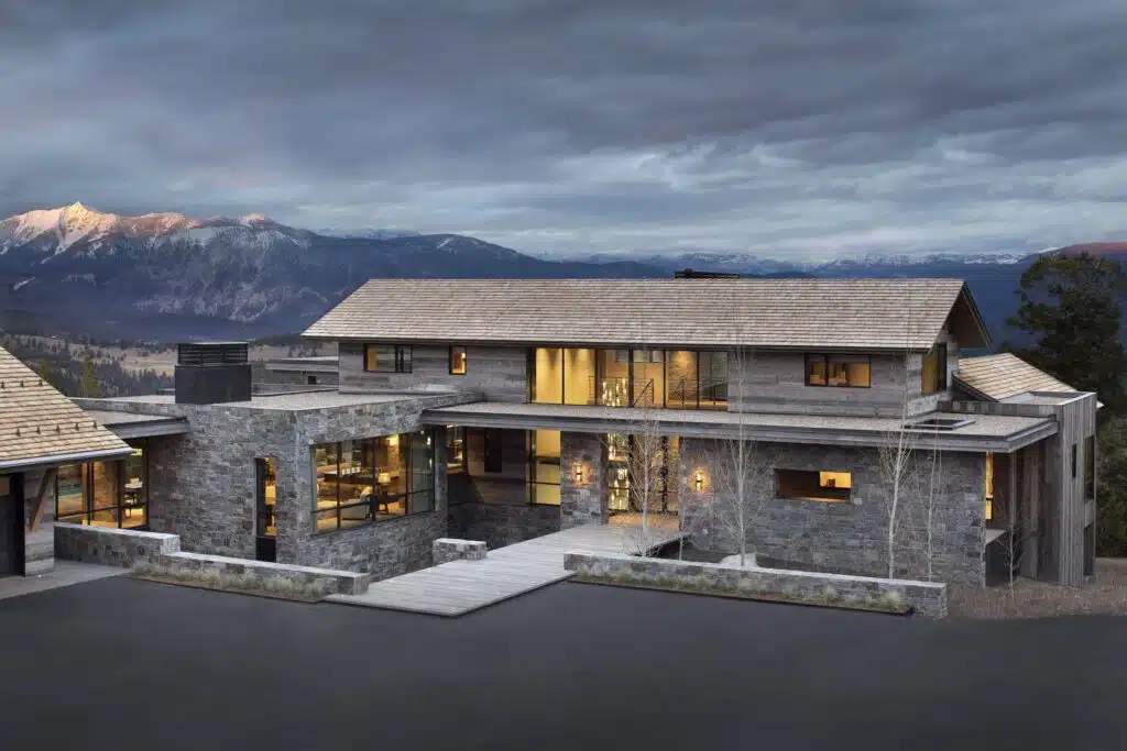Evening light on the stone and glass elevation of a completed custom home